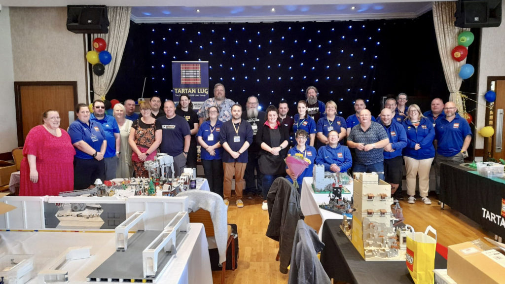 Tartan LUG members lined up inside the hall, most are wearing blue Tartan LUG shirts.