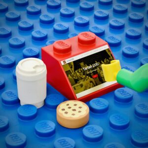 Minifigure hand operating a 2x2 45º slope computer, with coffee and cookie for snacks.